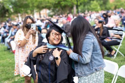 A Graduate is hooded. 