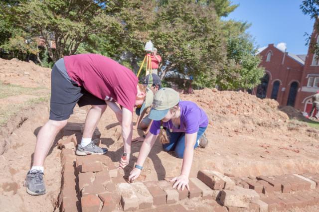 In a class-related archaeology survey, Ashton Chandler ’18, an anthropology major from Leesburg, and Jessica Keaton ’17, an anthropology major from Forest, uncover the foundation of the Richardson House in Bicentennial Park, which stood where the new admissions building will be built.