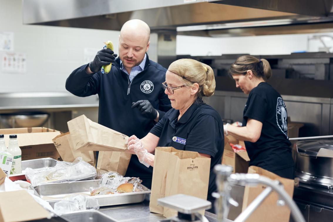 Adam Russo '07 working with staff in the kitchen